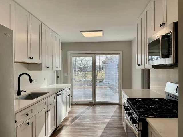 a kitchen with stainless steel appliances granite countertop a sink stove and cabinets
