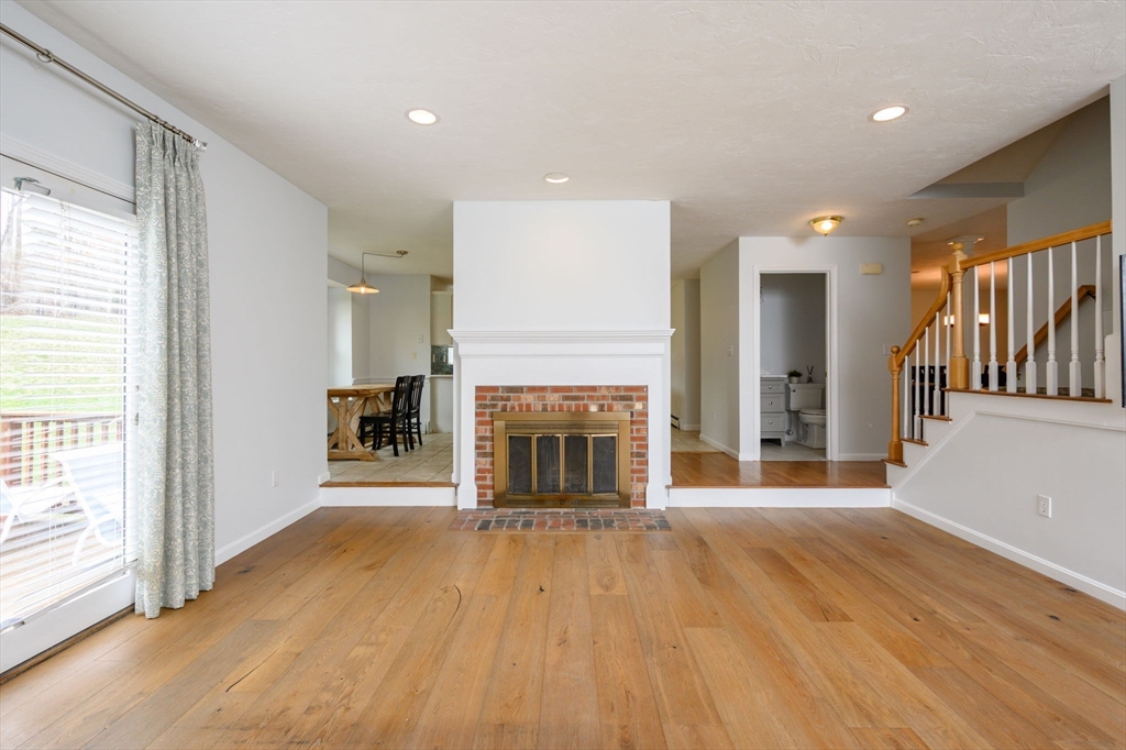 72 Pilgrim Trail Marshfield, MA 02050 - Photo 11 of 42 an empty room with wooden floor fireplace and windows