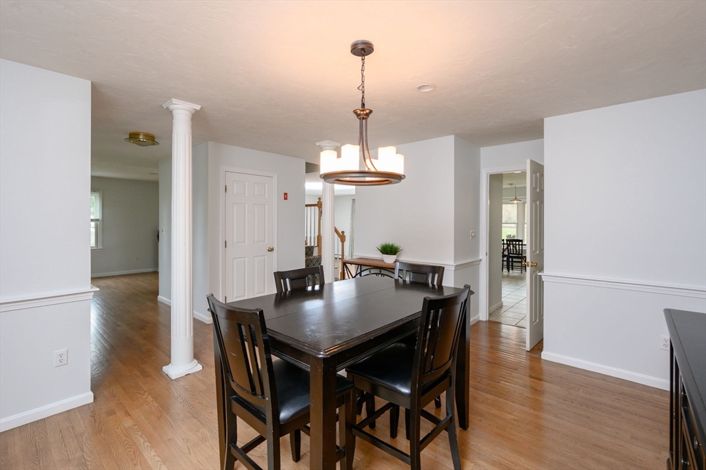 72 Pilgrim Trail Marshfield, MA 02050 - Photo 14 of 42 a dining room with wooden floor a chandelier a wooden table and chairs