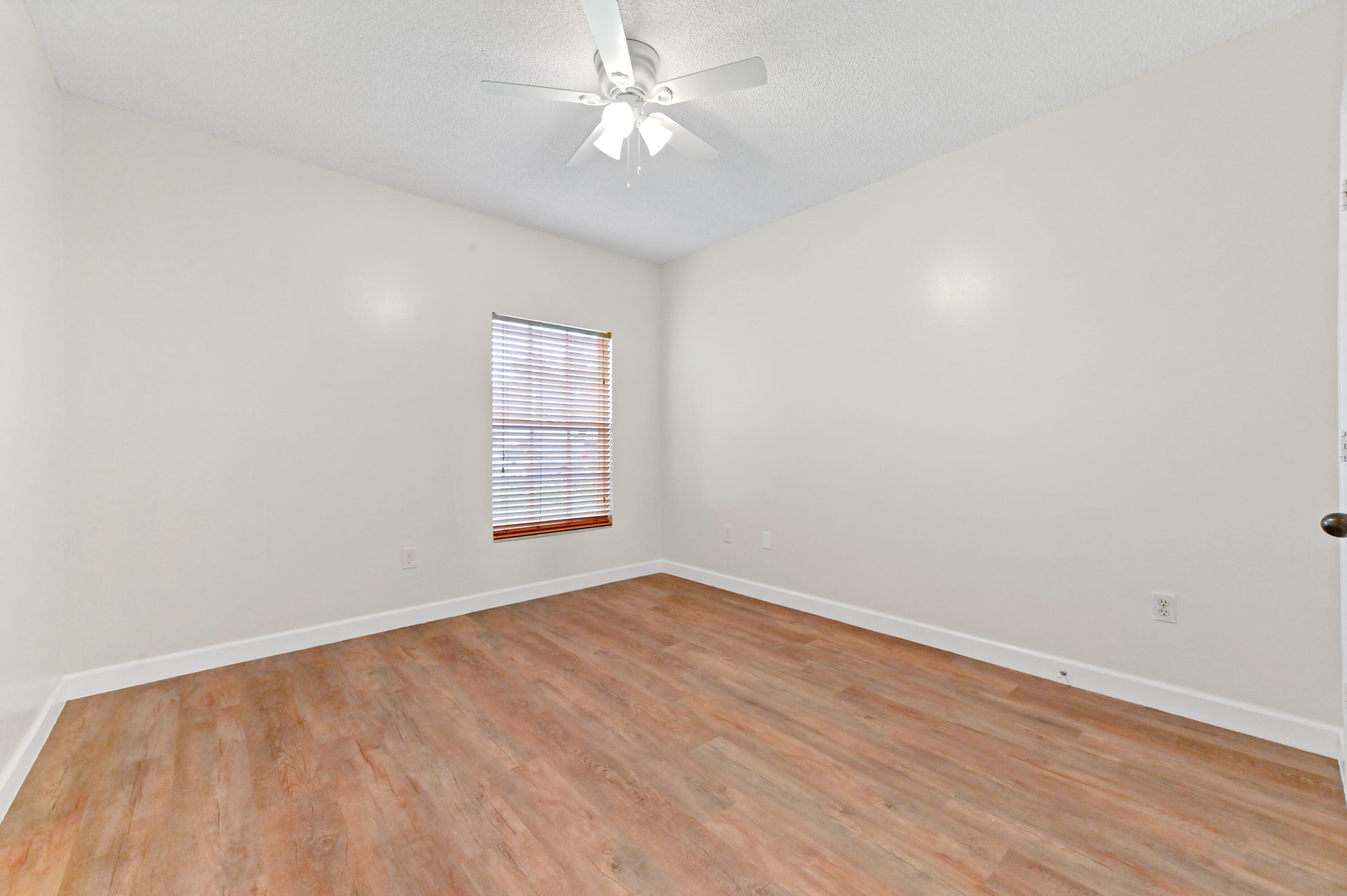 10306 Fox Trail Road South, Unit 906 West Palm Beach, FL 33411 - Photo 11 of 26 an empty room with a window and ceiling fan