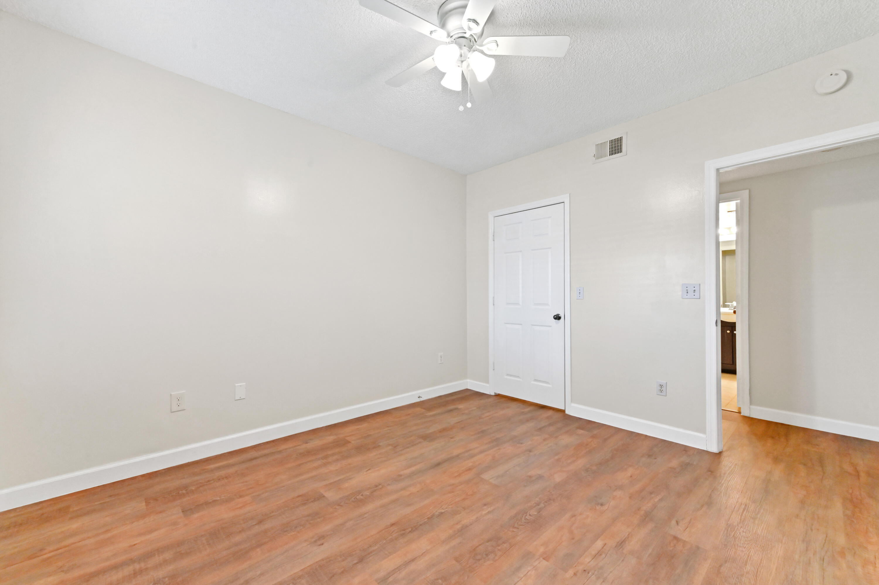 10306 Fox Trail Road South, Unit 906 West Palm Beach, FL 33411 - Photo 12 of 26 a view of an empty room with wooden floor