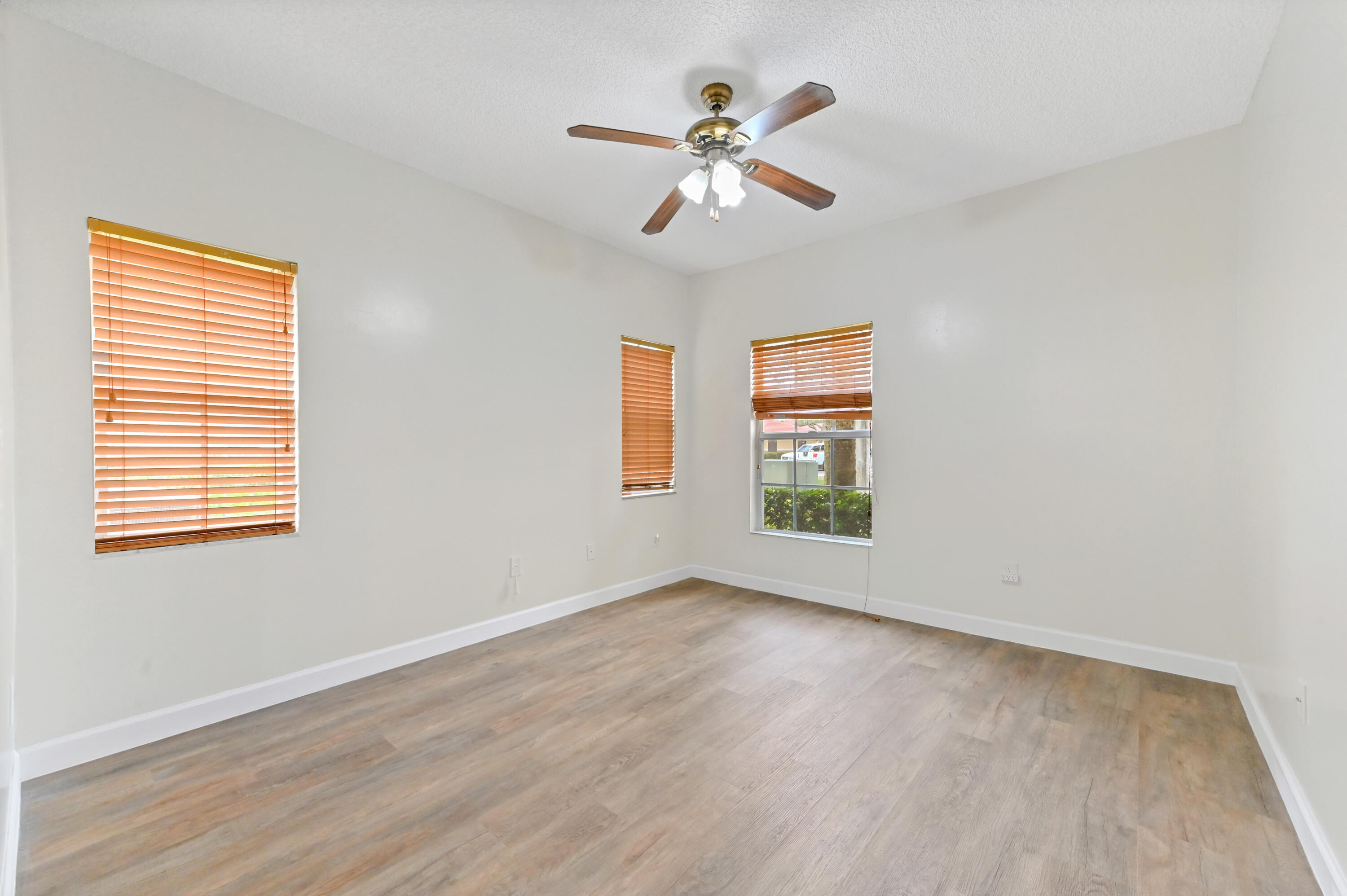 10306 Fox Trail Road South, Unit 906 West Palm Beach, FL 33411 - Photo 16 of 26 a view of empty room with wooden floor and fan