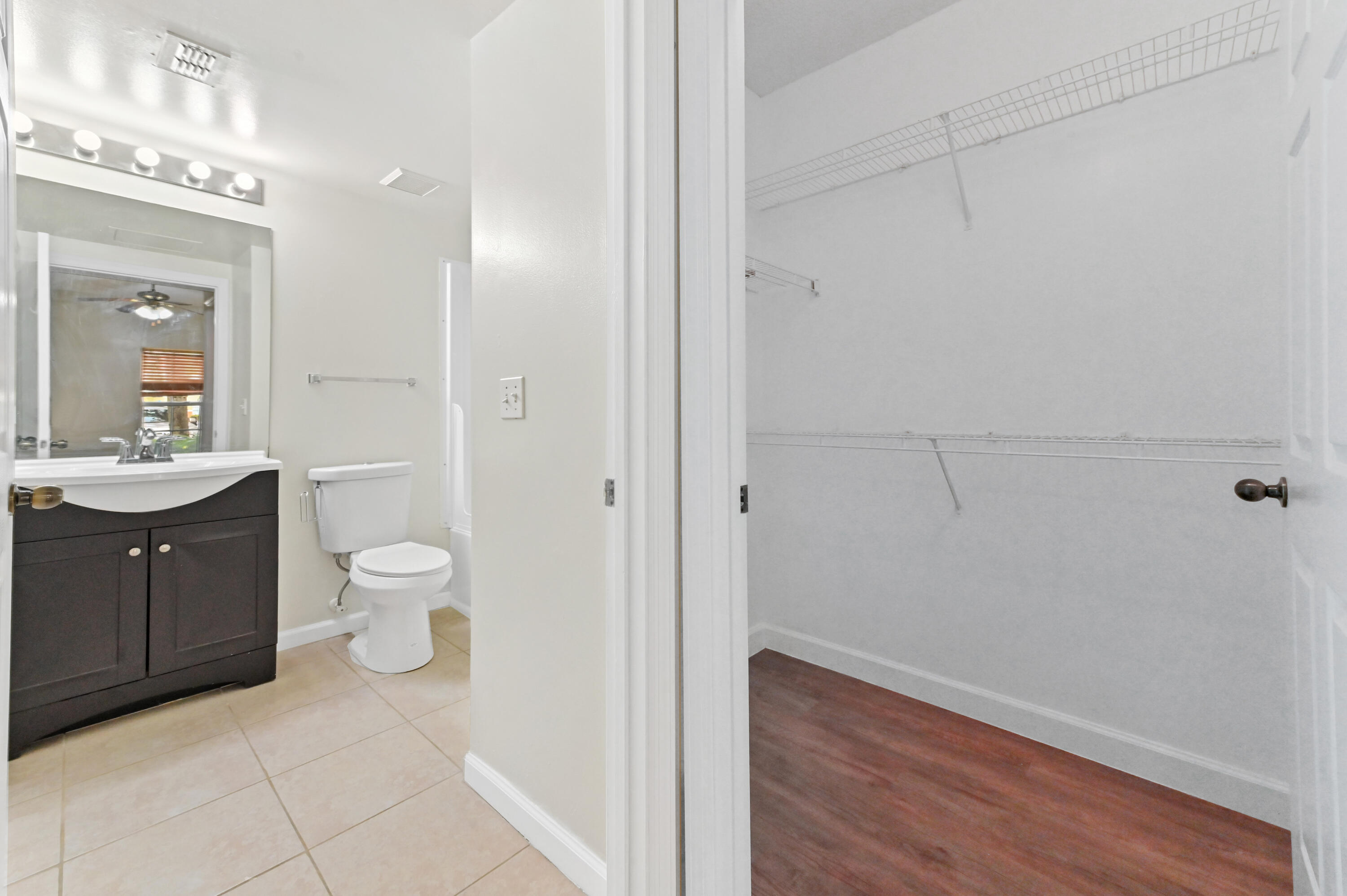 10306 Fox Trail Road South, Unit 906 West Palm Beach, FL 33411 - Photo 18 of 26 a spacious bathroom with a sink a toilet and a mirror