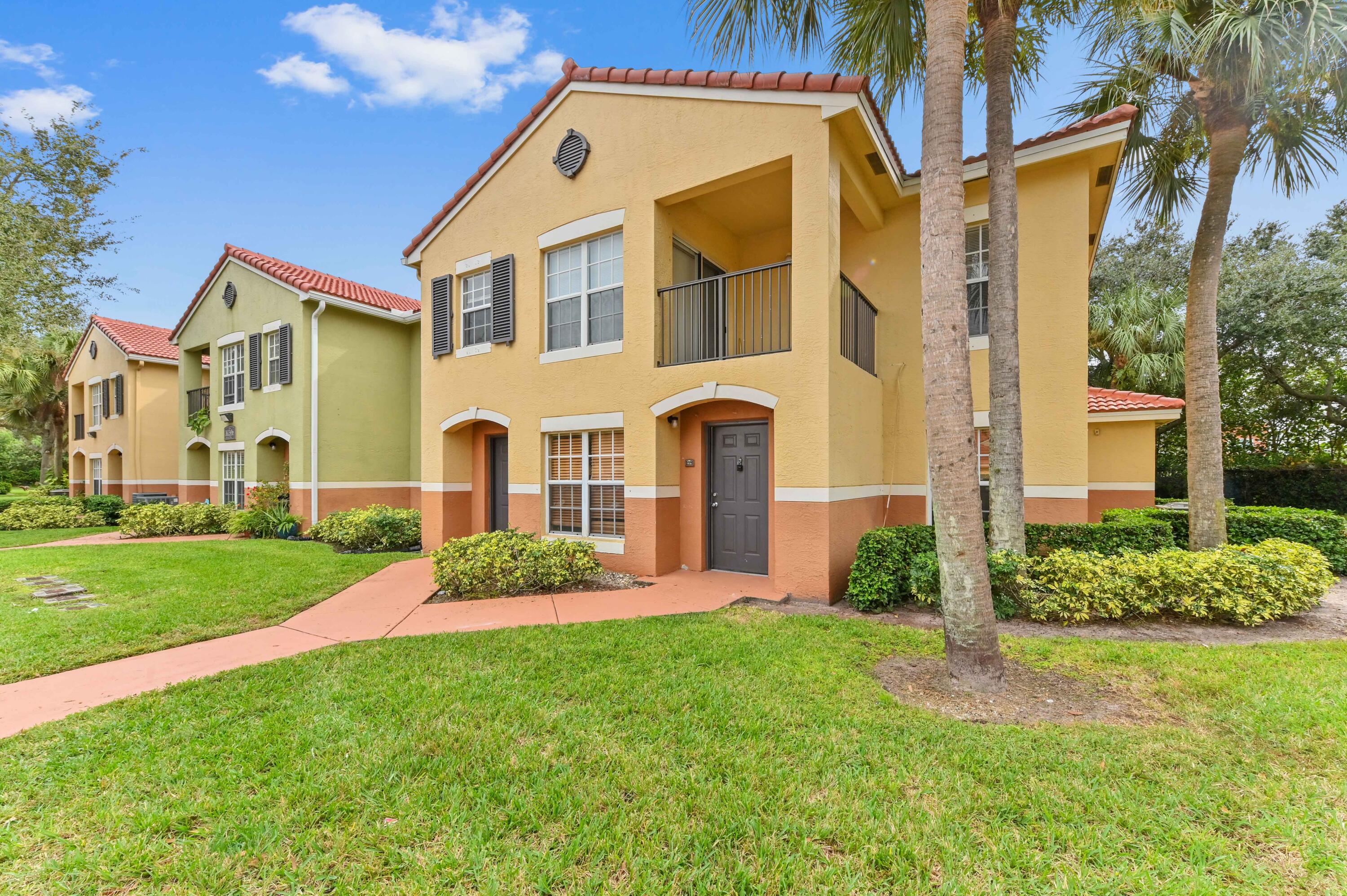 10306 Fox Trail Road South, Unit 906 West Palm Beach, FL 33411 - Photo 2 of 26 a front view of a house with a garden