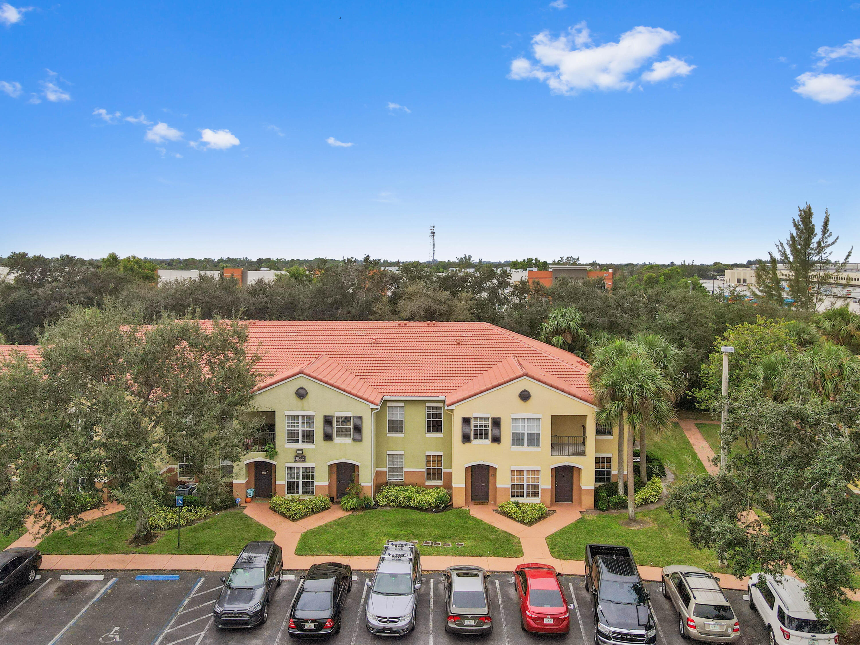 10306 Fox Trail Road South, Unit 906 West Palm Beach, FL 33411 - Photo 23 of 26 a view of a white house with a big yard and large trees