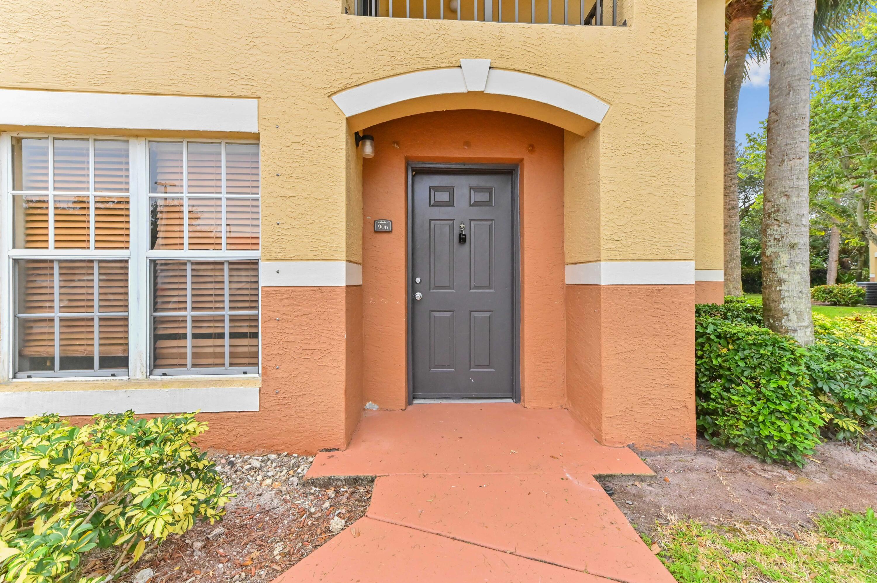 10306 Fox Trail Road South, Unit 906 West Palm Beach, FL 33411 - Photo 3 of 26 a front view of a house with a yard