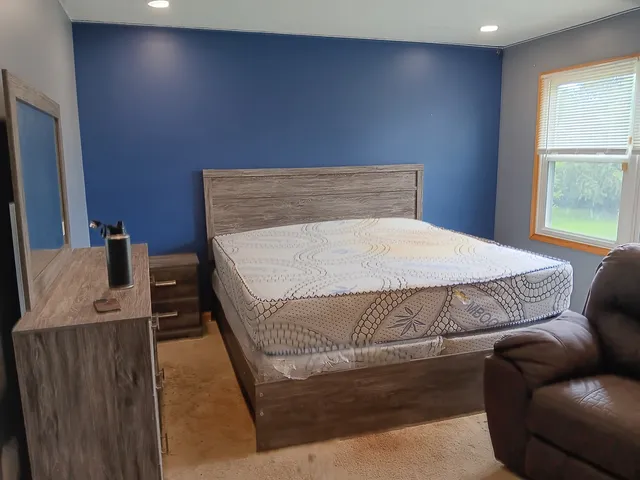 a bed sitting in a bedroom next to a window