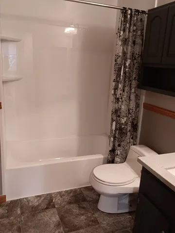 a white toilet sitting next to a bath tub
