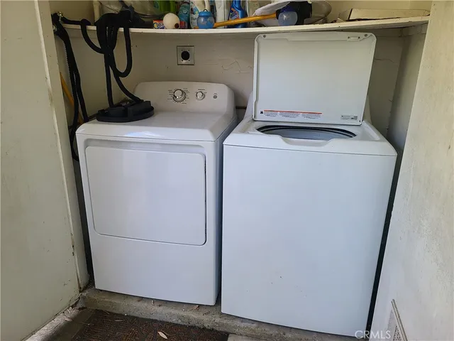 a view of a white house with a swimming pool and a large tree