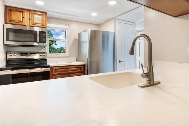 a kitchen with stainless steel appliances granite countertop a refrigerator and a stove top oven
