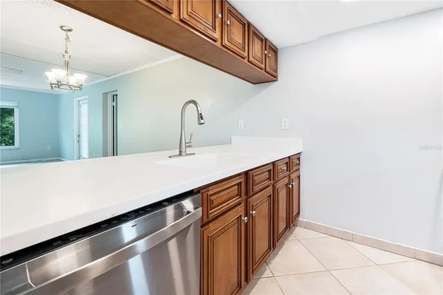 a kitchen with stainless steel appliances a sink and a chandelier