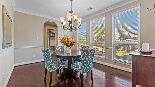 a view of a dining room with furniture a chandelier and wooden floor