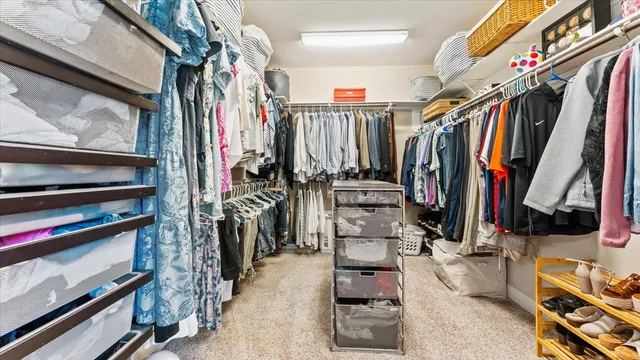 a view of walk in closet with clothes