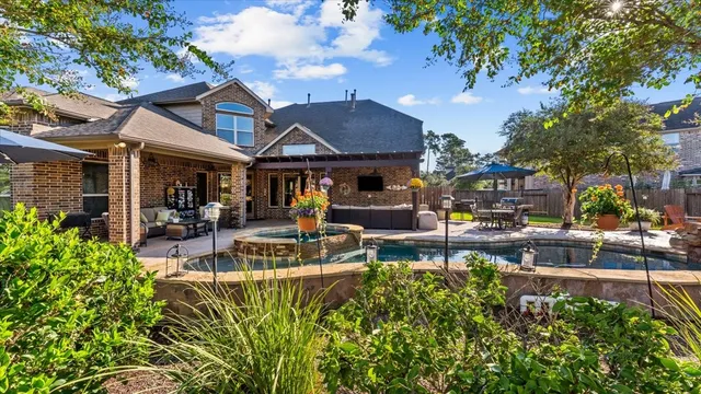 a view of a patio with table and chairs potted plants and a large tree