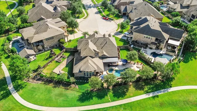 an aerial view of residential house with outdoor space and trees all around