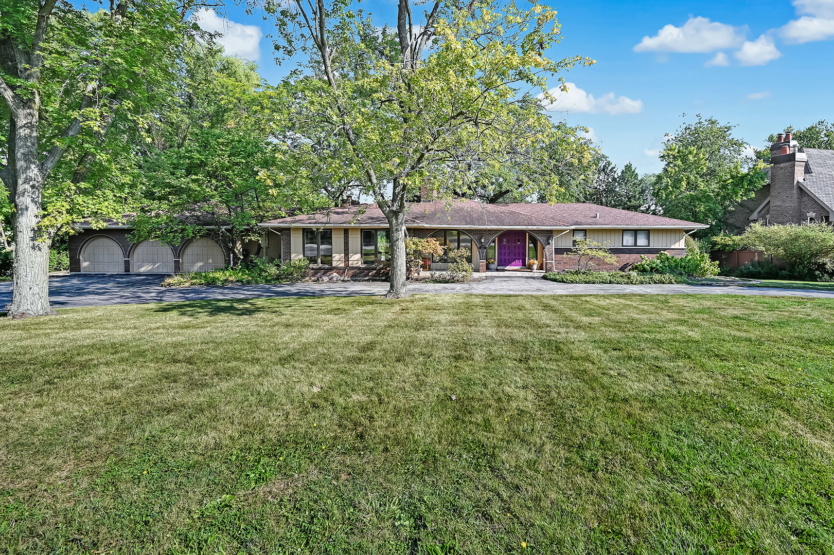 a view of a house with a big yard and large trees
