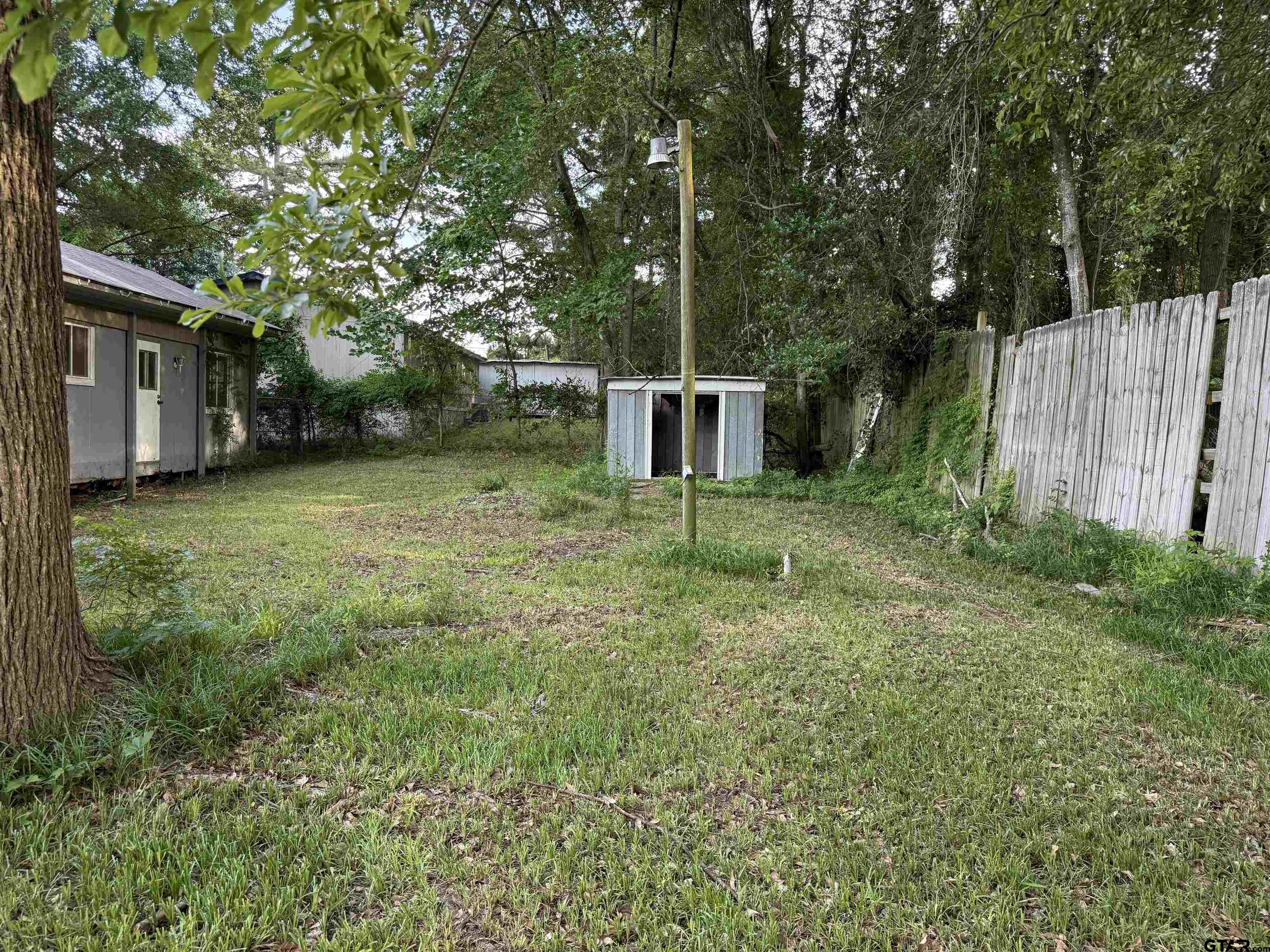 4604 Skyline Drive Chandler, TX 75758 - Photo 17 of 17 a backyard of a house with plants and large trees