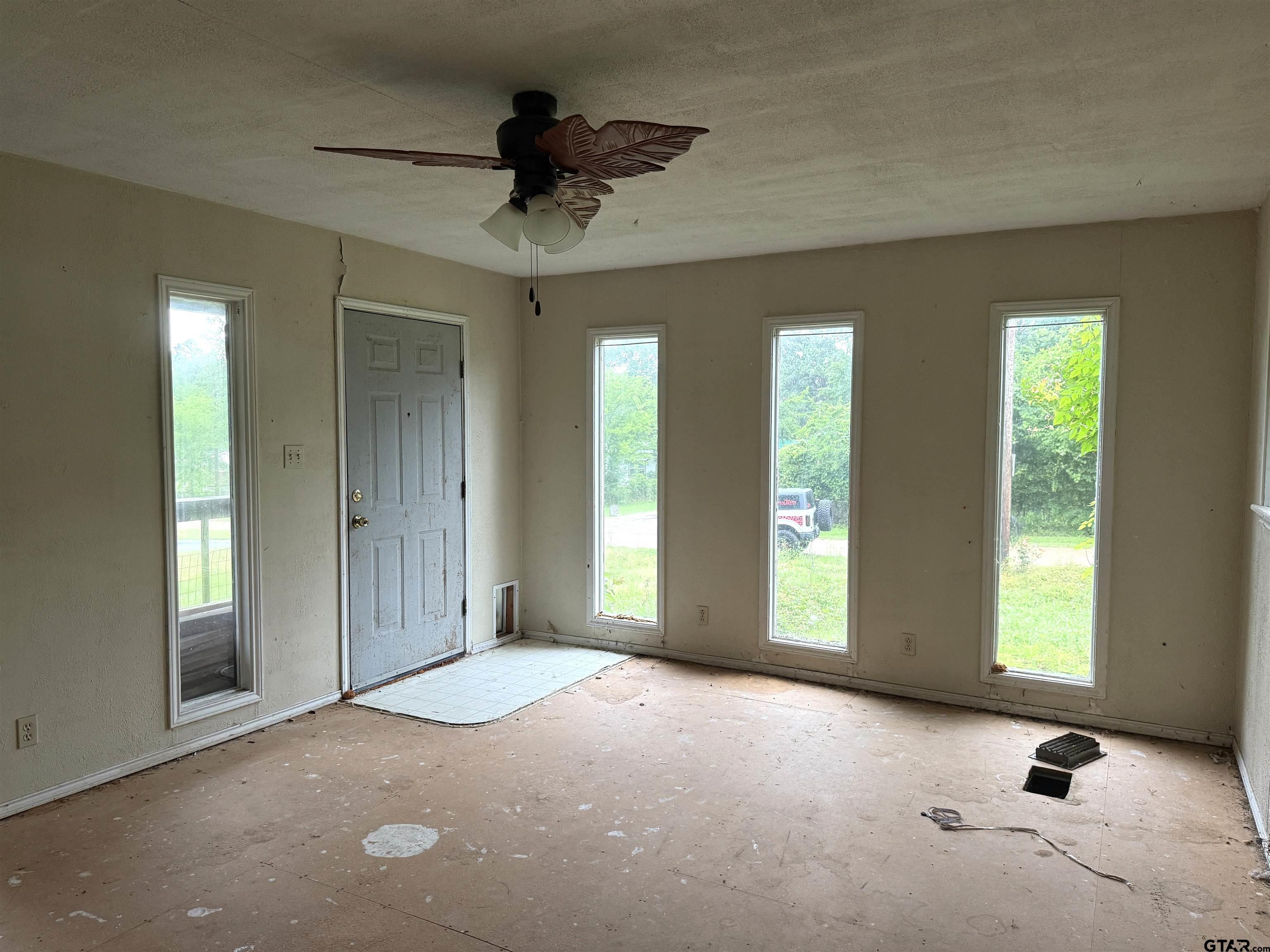 4604 Skyline Drive Chandler, TX 75758 - Photo 6 of 17 an empty room with windows and ceiling fan
