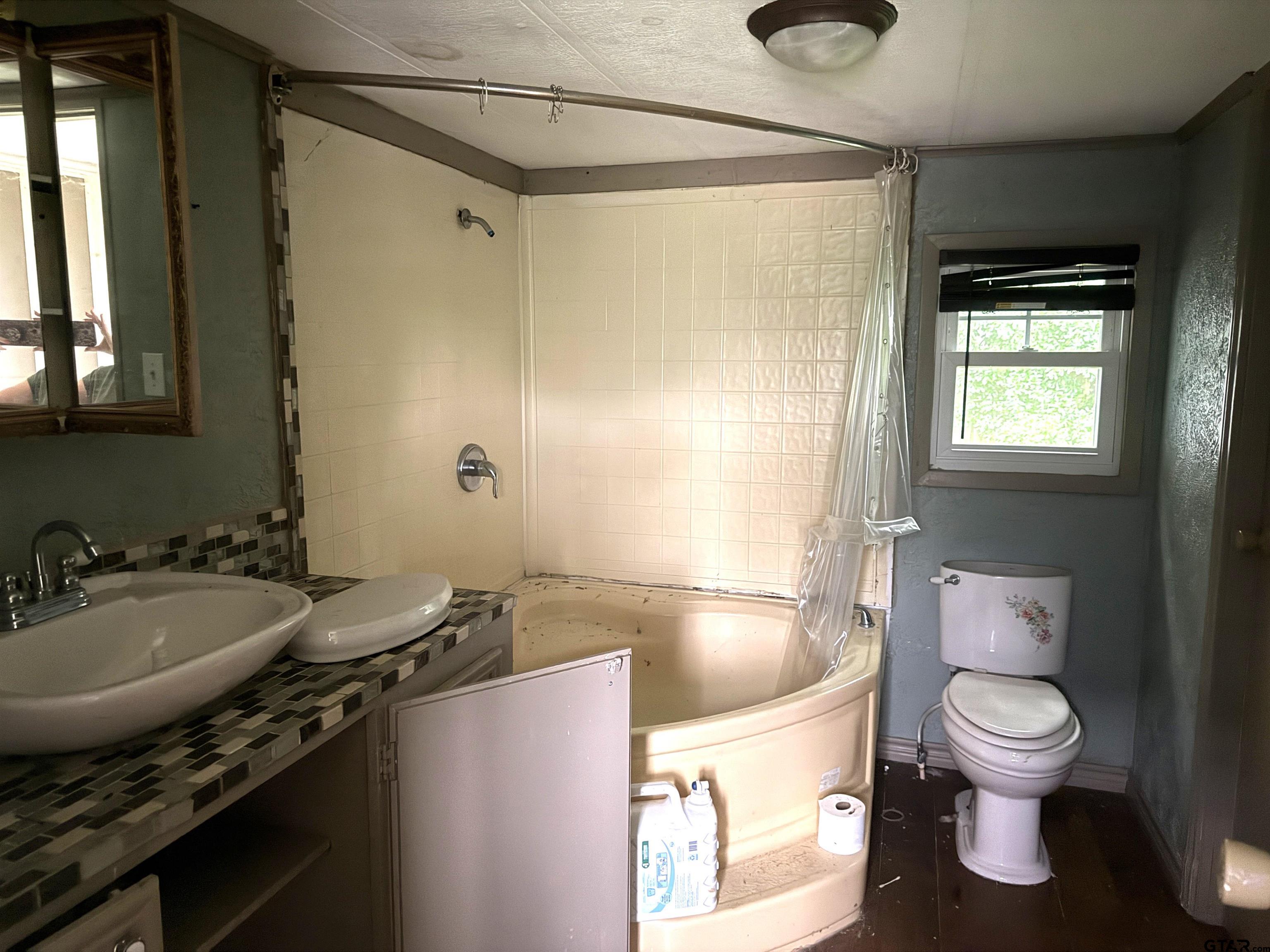 4604 Skyline Drive Chandler, TX 75758 - Photo 9 of 17 a bathroom with a granite countertop sink toilet and shower