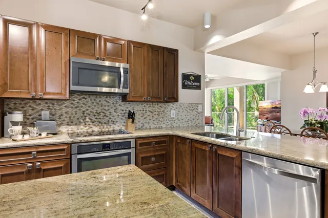 a kitchen with stainless steel appliances granite countertop a sink stove and microwave