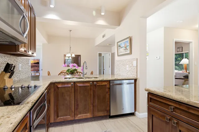 a kitchen with stainless steel appliances granite countertop a sink and a refrigerator
