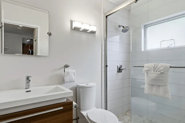 a bathroom with a sink a toilet and shower