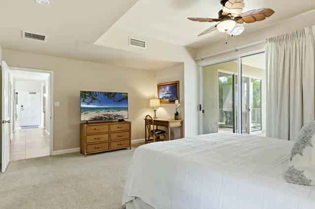a large bedroom with a bed and a chandelier
