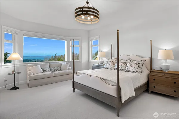 a bedroom with a large bed and a chandelier