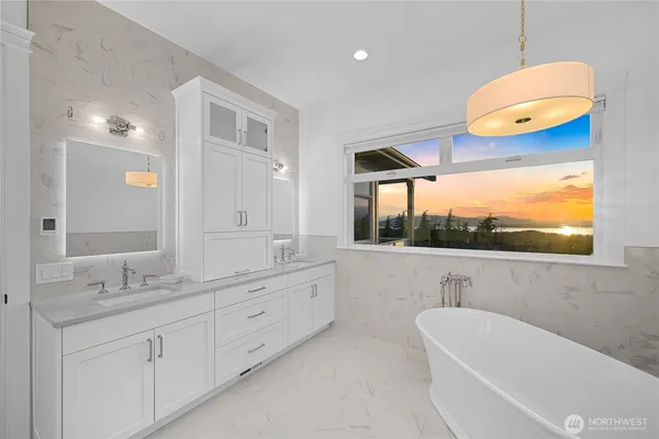 a bathroom with a sink a large mirror and a bathtub