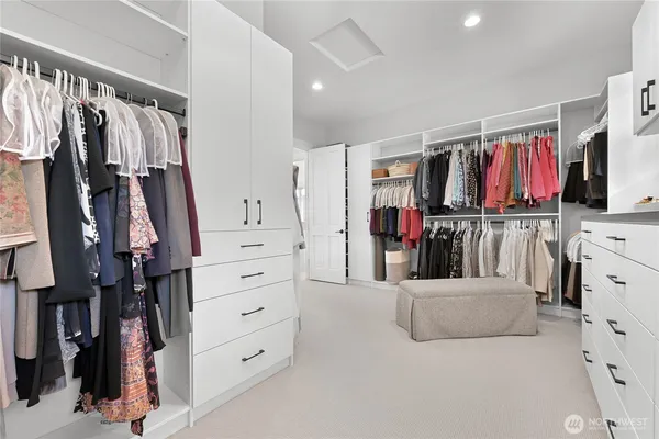 a view of walk in closet with clothes and shoes