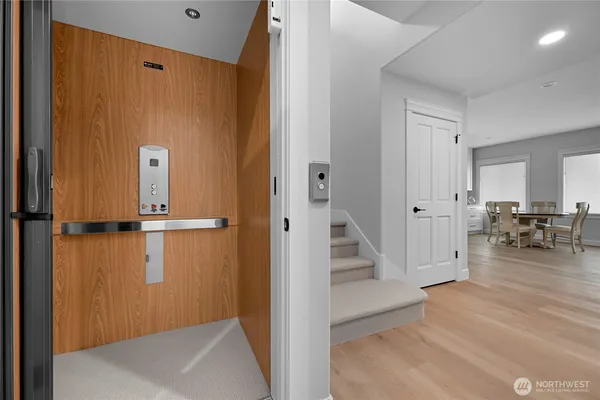 a view of a hallway with wooden floor and dining room view