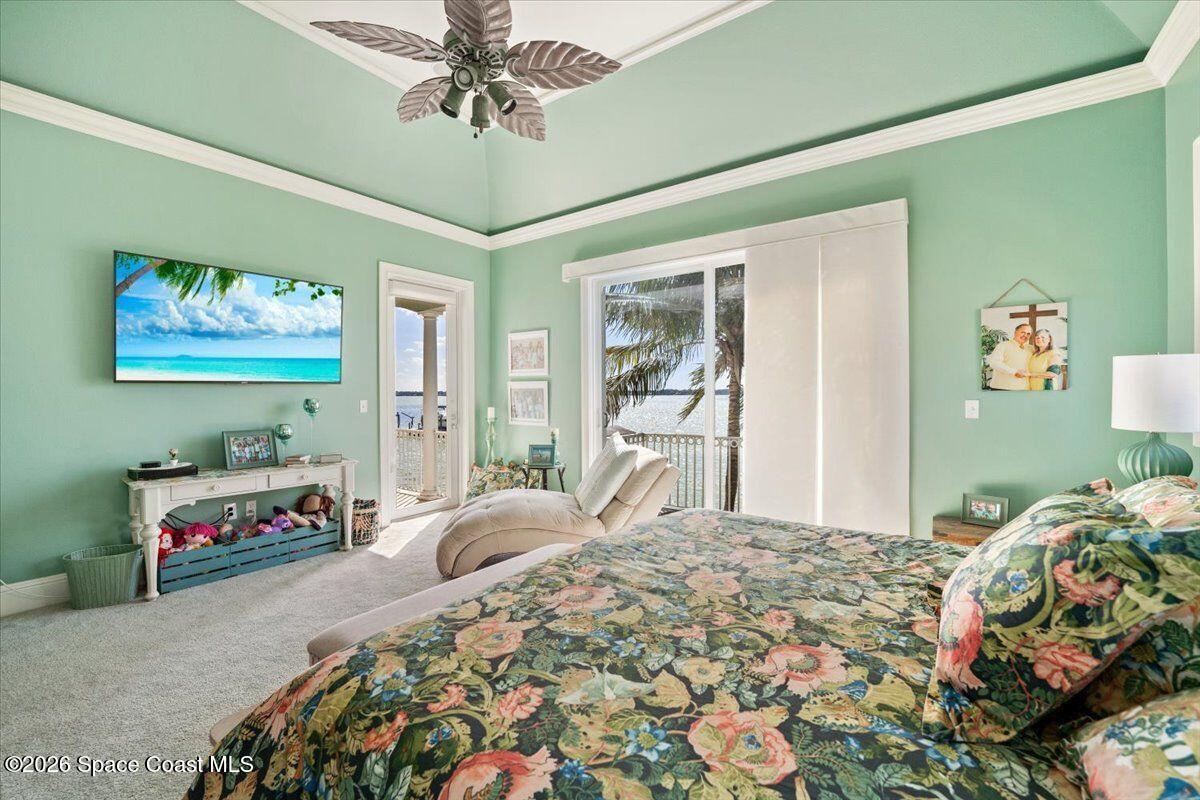 2555 South Tropical Trail Merritt Island, FL 32952 - Photo 19 of 91 a bedroom with a bed and a chandelier