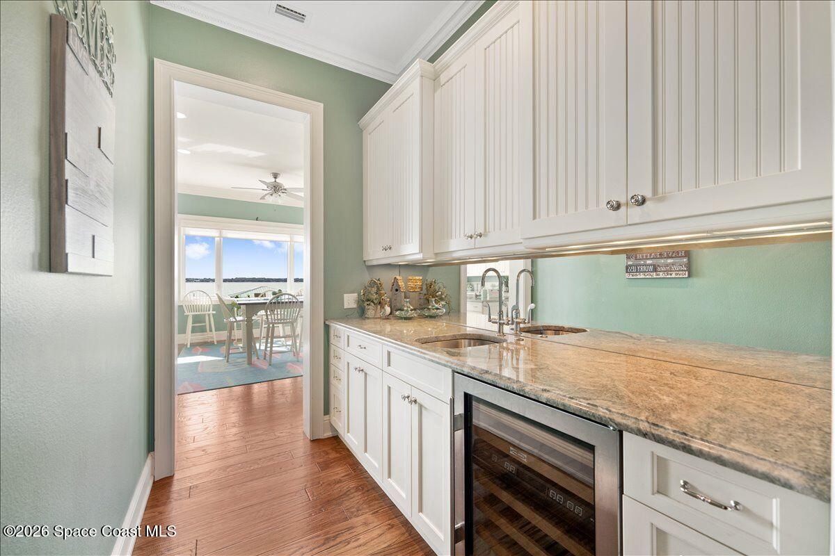 2555 South Tropical Trail Merritt Island, FL 32952 - Photo 31 of 91 a kitchen with granite countertop a sink and dishwasher with white cabinets