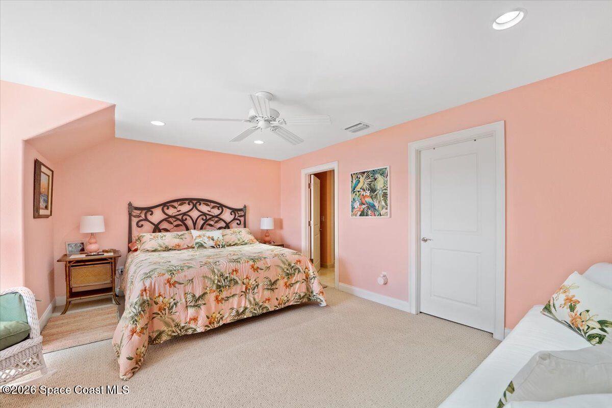 2555 South Tropical Trail Merritt Island, FL 32952 - Photo 36 of 91 a bedroom with a bed and a chandelier