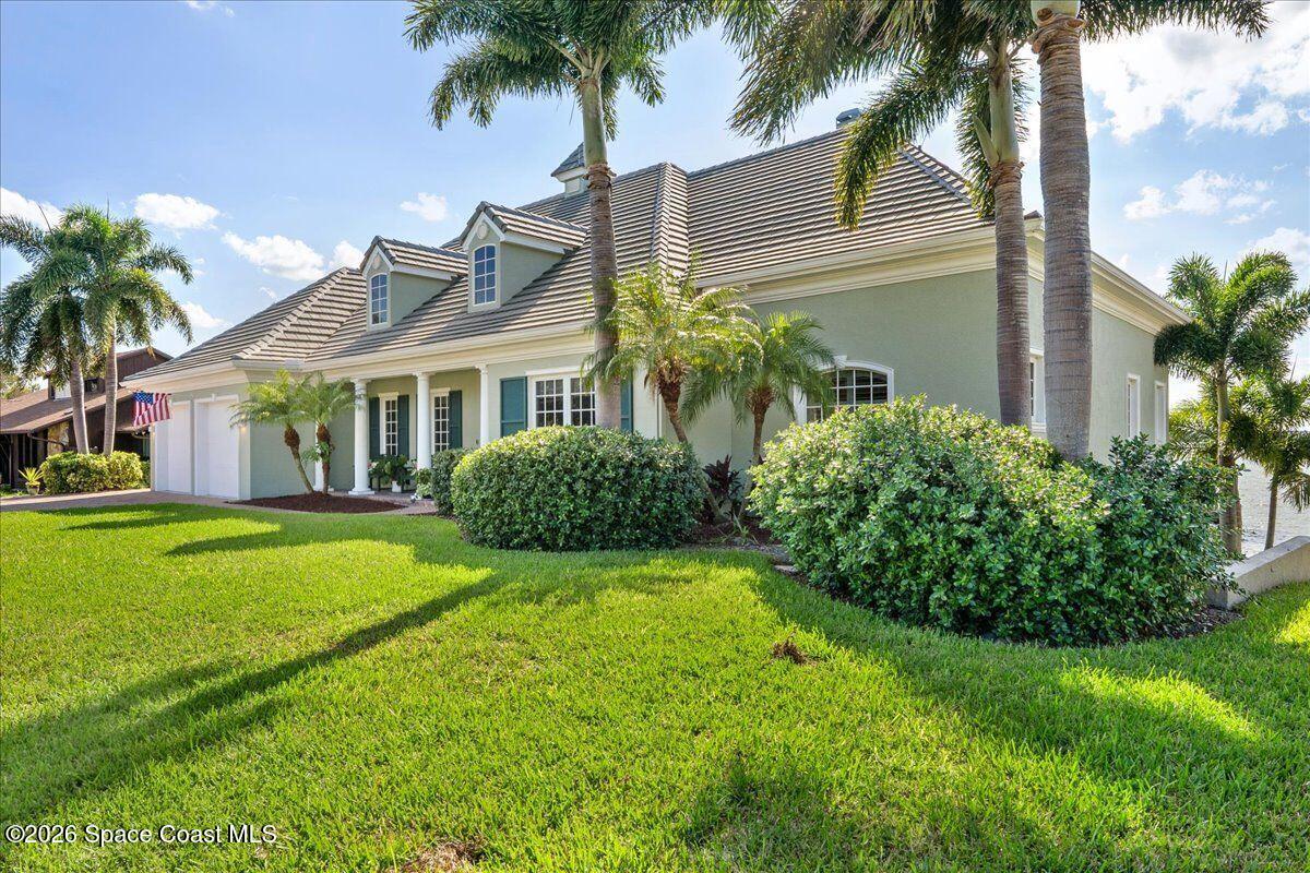 2555 South Tropical Trail Merritt Island, FL 32952 - Photo 4 of 91 a view of a house with a yard and palm trees