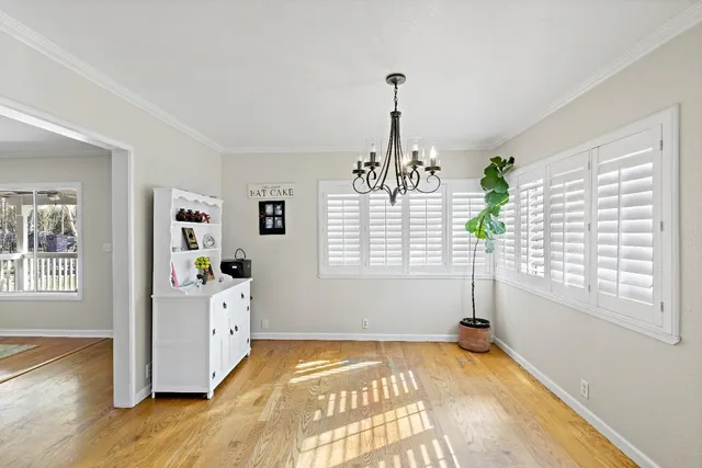 a view of empty room with window and wooden floor