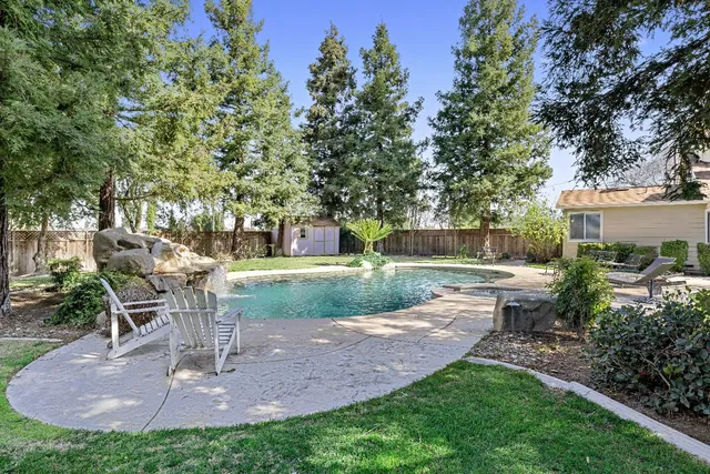 a view of a chair and table in backyard of the house
