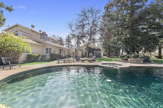 a swimming pool with outdoor seating and yard