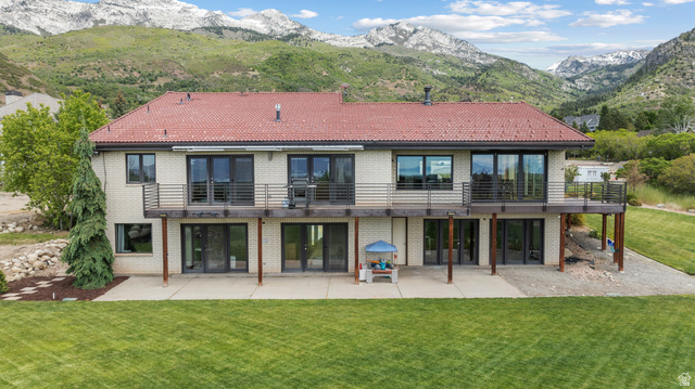 4221 Juniper Circle Alpine, UT 84004 - Photo 47 of 66 Rear exterior featuring a full-width upper deck with metal railings, ground-level patio space, and a red tile roof