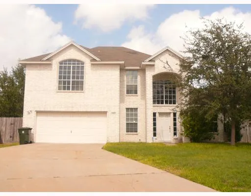 a view of a large white house with a yard