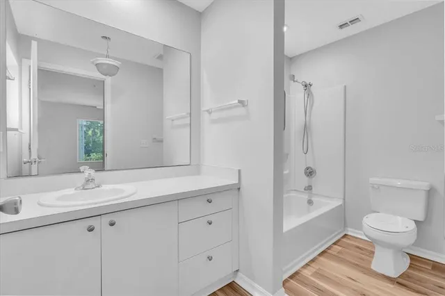 a bathroom with a sink a toilet and a large mirror