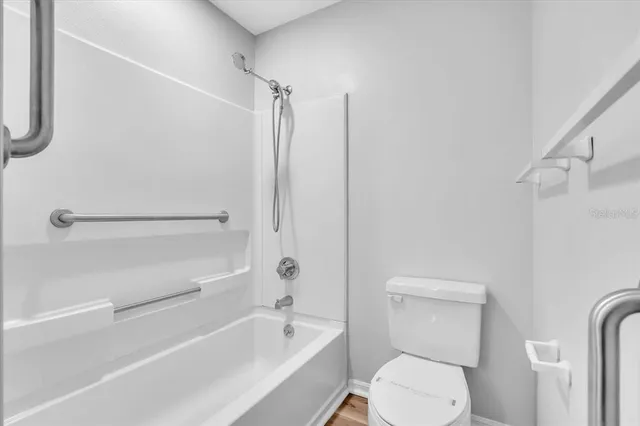 a white toilet sitting next to a bath tub