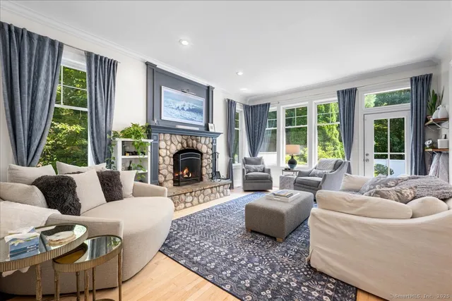 a living room with furniture large window and fireplace