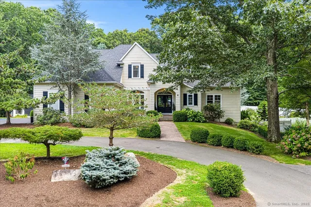 a front view of a house with a yard and a garden