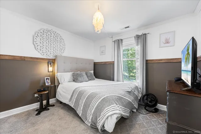 a bedroom with a bed and a chandelier