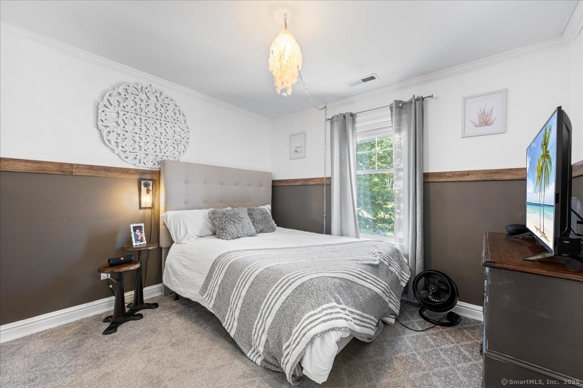 4 Laconia Drive Clinton, CT 06413 - Photo 23 of 40 a bedroom with a bed and a chandelier