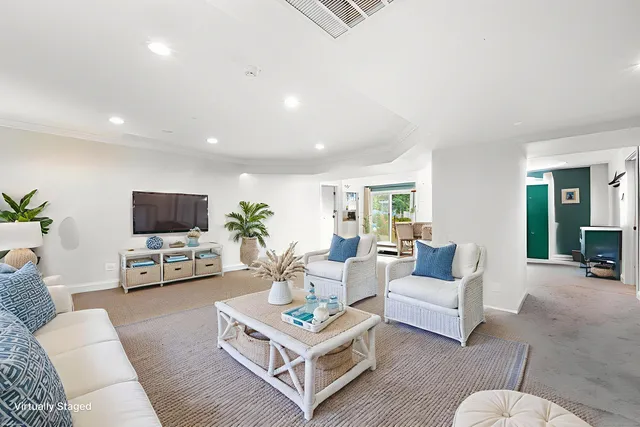 a living room with furniture a flat screen tv and a table