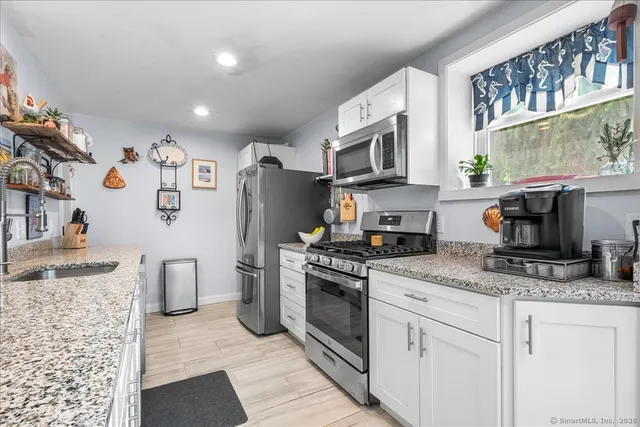 a kitchen with stainless steel appliances granite countertop a stove a sink and a granite counter tops