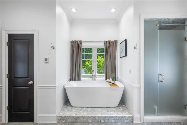 a white bath tub sitting in a bathroom next to a window
