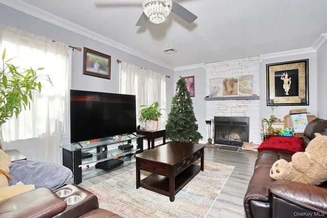 a living room with furniture a flat screen tv and a dining table with wooden floor